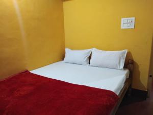 1 dormitorio con cama blanca y manta roja en Mountain view pinak stay, en Madikeri