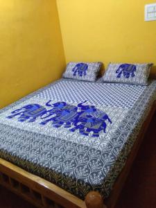 Cama con sábanas y almohadas azules y blancas en Mountain view pinak stay, en Madikeri