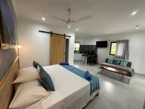 een slaapkamer met een bed en een woonkamer bij VincVilla in Anse Possession