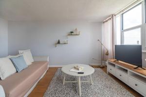 a living room with a couch and a tv and a table at Bright DT Apt #7A, Amazing View in Halifax