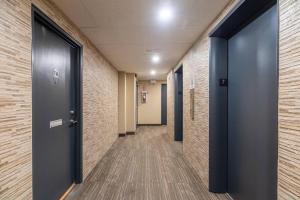 a hallway of an office with blue doors and brick walls at Bright DT Apt #7A, Amazing View in Halifax