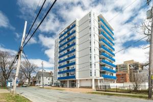 a tall white building with blue windows on a street at Bright DT Apt #7A, Amazing View in Halifax