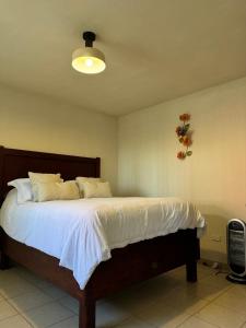een slaapkamer met een groot bed met witte lakens bij Suite AMAI, Valle de Guadalupe in Colonia de Guadalupe