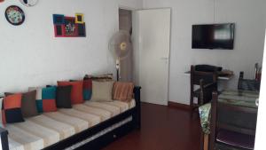 sala de estar con sofá y almohadas coloridas en Barracuda 7 en Santa Teresita