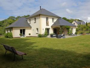 une maison blanche avec un banc dans l'herbe dans l'établissement Vauclair, à Pléneuf-Val-André