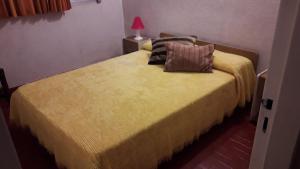 1 dormitorio con 1 cama con colcha amarilla en Barracuda 7 en Santa Teresita
