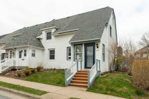 a white house with a gray roof and stairs at Charming Townhouse, Historic Hydrostone in Halifax