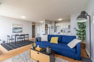 a living room with a blue couch and a kitchen at Spacious Downtown Apt #9A, Amazing View in Halifax