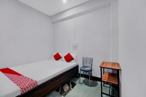 a bedroom with a bed and a table and a chair at OYO Flagship YUVRAJ Hotel in Patna