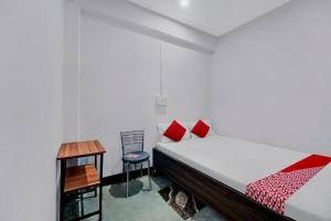 a bedroom with a bed and a desk and a chair at OYO Flagship YUVRAJ Hotel in Patna