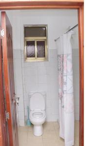 een badkamer met een toilet en een raam bij 3 BEDROOM LIWANDO HOME at Greatwall Gardens next to Greatwall Mall, 15 Minutes from JKIA Airport With FREE WIFI & Parking, Enjoy Entire Unit in a Gated Community manned with Security 24 Hours in Athi River
