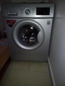 a washing machine is sitting in a room at 3 BEDROOM LIWANDO HOME at Greatwall Gardens next to Greatwall Mall, 15 Minutes from JKIA Airport With FREE WIFI & Parking, Enjoy Entire Unit in a Gated Community manned with Security 24 Hours in Athi River +5 photos