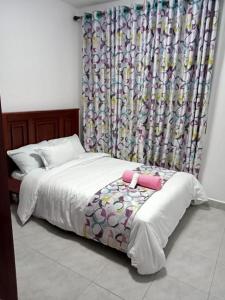 1 dormitorio con 1 cama con cortina de ducha en 3 BEDROOM LIWANDO HOME at Greatwall Gardens next to Greatwall Mall, 15 Minutes from JKIA Airport With FREE WIFI & Parking, Enjoy Entire Unit in a Gated Community manned with Security 24 Hours, en Athi River