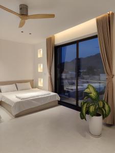 een slaapkamer met een bed en een groot raam bij Light House Motel 978 in Long Hai