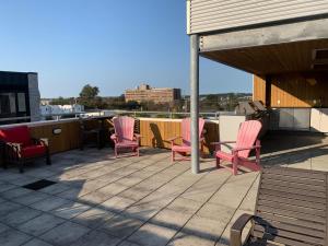 eine Gruppe rosafarbener Stühle auf dem Dach in der Unterkunft Tasteful Apt #108, Shared Rooftop Area in Halifax