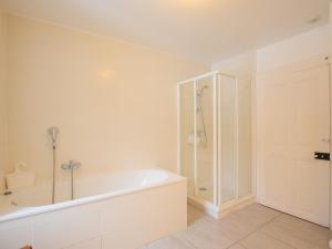 a white bathroom with a tub and a shower at Maison Lugrin, 7 pièces, 12 personnes - FR-1-498-100 in Lugrin