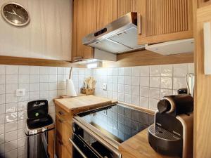 a small kitchen with a stove and a microwave at Appartement Méribel, 2 pièces, 5 personnes - FR-1-688-75 in Méribel