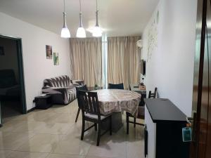 a kitchen and living room with a table and chairs at Taragon Suits Apartment KL in Kuala Lumpur