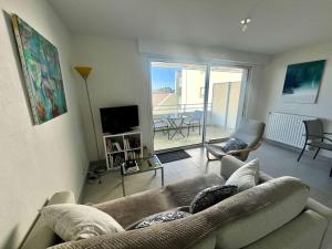 ein Wohnzimmer mit einem Sofa und einem TV in der Unterkunft Appartement Étel, 2 pièces, 4 personnes - FR-1-479-155 in Étel
