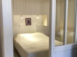 um pequeno quarto com uma cama e um espelho em Studio Saint-Martin-de-Ré, 2 pièces, 4 personnes - FR-1-544-25 em Saint-Martin-de-Ré