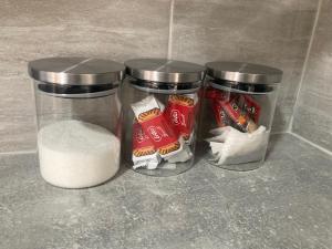 three glass jars filled with food and a pile of sugar at Riverside by Teil Luxurious one bed Apartment in Preston