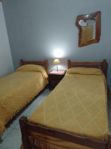 - 2 lits dans une chambre avec un miroir et une table dans l'établissement Don Nieto, à Chos Malal