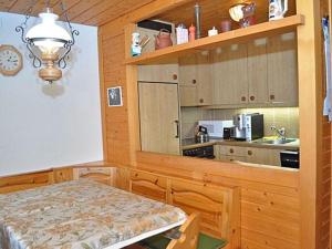 una cocina con armarios de madera y una mesa en una habitación en Rottal 4 Bett Wohnung - b48810, en Mürren