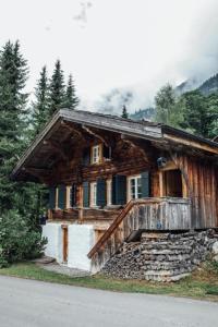 ein Blockhaus mit einer Veranda an der Straßenseite in der Unterkunft Alphütte - Ferienchalet Berner Oberland Schweiz - Fermeltal 20min von Gstaad - b48817 