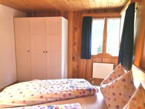 een slaapkamer met een bed, een kast en ramen bij Neu eingerichtete Ferienwohnung im Haslital - b48815 in Innertkirchen