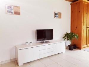 - un salon avec une télévision sur un meuble blanc dans l'établissement Neu eingerichtete Ferienwohnung im Haslital - b48815, à Innertkirchen
