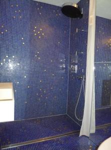 a bathroom with a shower with a blue tiled wall at Chesa Blais , 1 Stock - b48820 in Zuoz