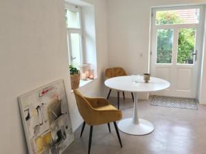 uma mesa branca e cadeiras num quarto com uma porta em Kleines, cooles Loft im Appenzellerland - b48859 em Gais
