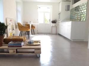 a living room with a coffee table and a kitchen at Kleines, cooles Loft im Appenzellerland - b48859 in Gais