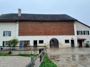 un gran edificio blanco con un marrón y blanco en Wohnung im Bauerhof - b48860, en Luins