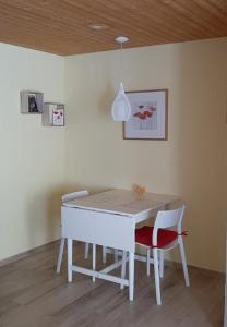 une table à manger avec deux chaises et un plafond dans l'établissement Rothorn-Center A 1OG- Schöpfer - b48829, à Sörenberg