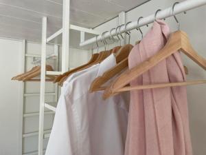 a closet with wooden hangers and a pink towel at Ferienwohnung im Dorf Urnäsch - b48863 in Urnäsch