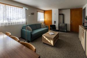 ein Wohnzimmer mit einem Sofa und einem Tisch in der Unterkunft Familienfreundliche Ferienwohnung mit Spielwiese Haus Reanchme Parterre - b48833 in Sörenberg