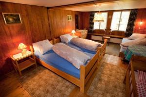 2 camas en una habitación con paredes de madera en 45 Zimmer Ferienwohnung Hofstatthaus - b48818, en Hasliberg
