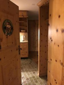 - une porte ouverte dans la cuisine dotée de murs en bois dans l'établissement Chesa Trafögl - b48847, à Pontresina