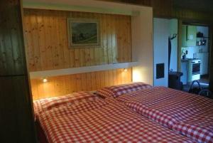 - une chambre avec un lit à damiers rouge et blanc dans l'établissement Chalet Huusli - b48809, à Axalp