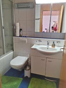 a bathroom with a sink and a toilet and a mirror at Rothorn-Center C direkt im Dorfzentrum - b48865 in Sörenberg