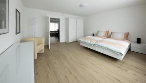 Habitación blanca con cama y escritorio en Moderne Landwohnung Tokyo im Thurgau - b48854 