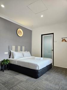 een slaapkamer met een groot bed en een klok aan de muur bij Luna Hotel by Moonknight in George Town
