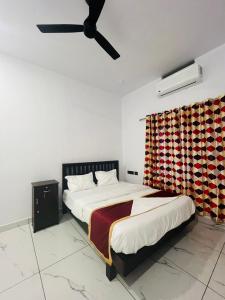 RAJAGIRI Heaven في Alwaye: غرفة نوم بسرير ومروحة سقف