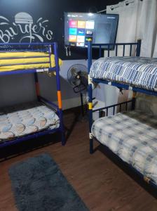 Zimmer mit 2 Etagenbetten und einem TV in der Unterkunft Alojamiento chillan in Chillán