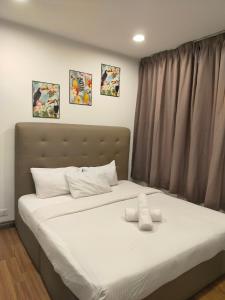 a bed with two white pillows on it in a room at Taragon Suits Apartment KL in Kuala Lumpur