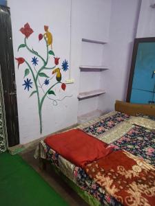 a bedroom with a wall with a mural of flowers at Shiva guest House (hoche poche cafe ) in Agra