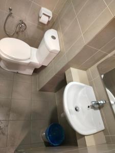 a bathroom with a toilet and a sink at Taragon Suits Apartment KL in Kuala Lumpur
