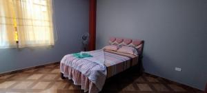 a small bedroom with a bed with a pink headboard at PARAISO in Puerto Callao