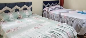 1 dormitorio con 2 camas con sábanas rosas y blancas en PARAISO, en Puerto Callao